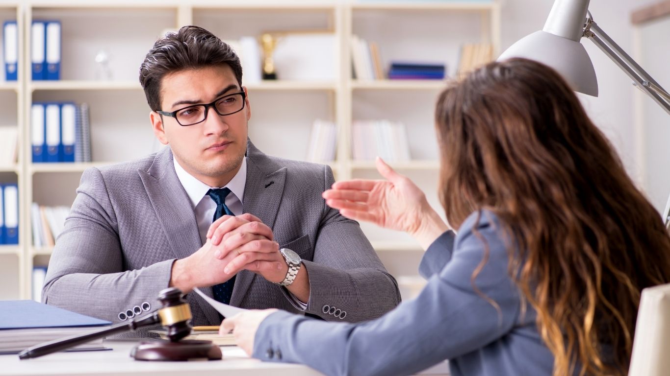 New York attorney advising a client who is being sued during a legal consultation in a modern NYC law office.